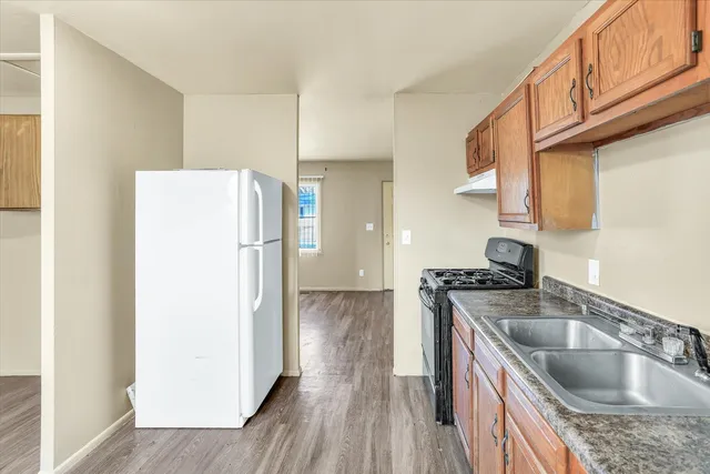 a kitchen with a refrigerator sink and wooden cabinets