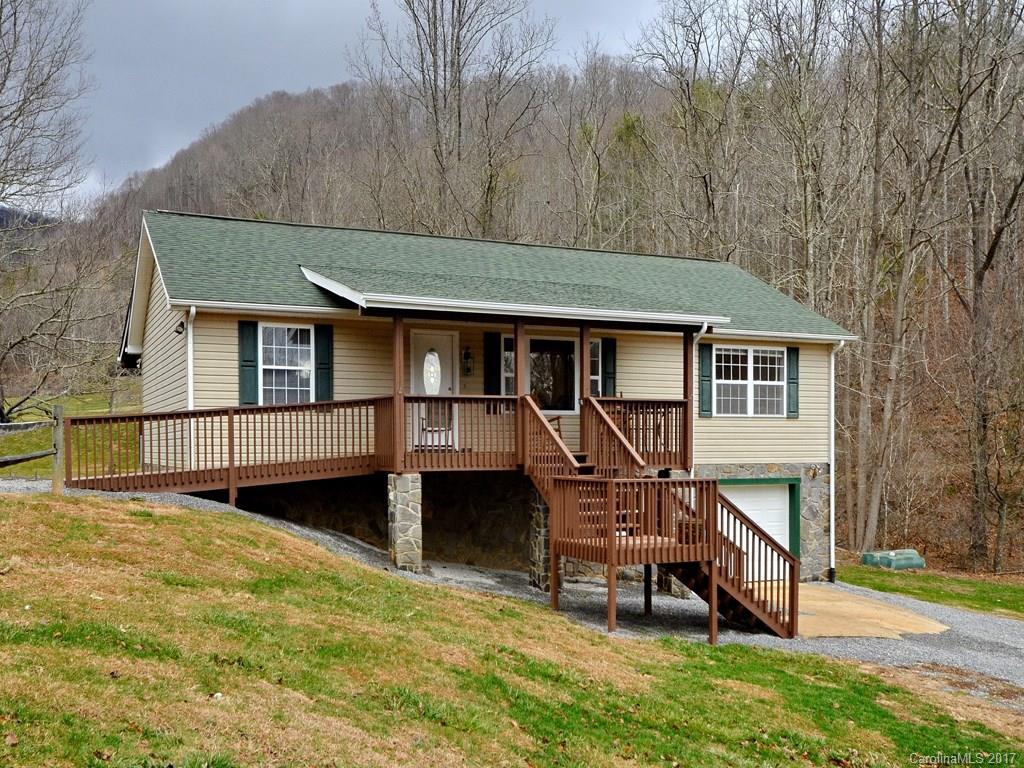1010 Wesley Creek Road Clyde, NC 28721 - Photo 1 of 12 a backyard of a house with wooden deck and outdoor seating