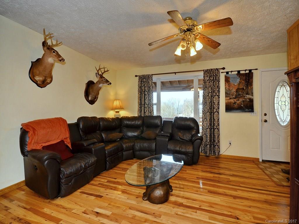 1010 Wesley Creek Road Clyde, NC 28721 - Photo 3 of 12 a living room with furniture and a chandelier