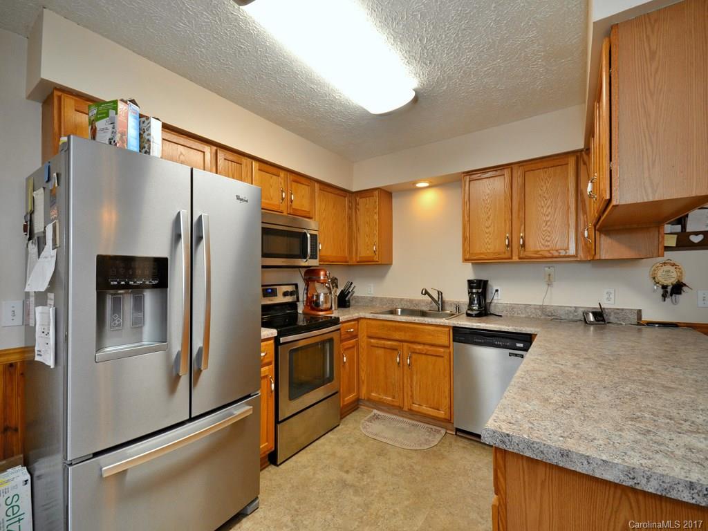 1010 Wesley Creek Road Clyde, NC 28721 - Photo 5 of 12 a kitchen with stainless steel appliances granite countertop a refrigerator a sink dishwasher a stove top oven a refrigerator and cabinets