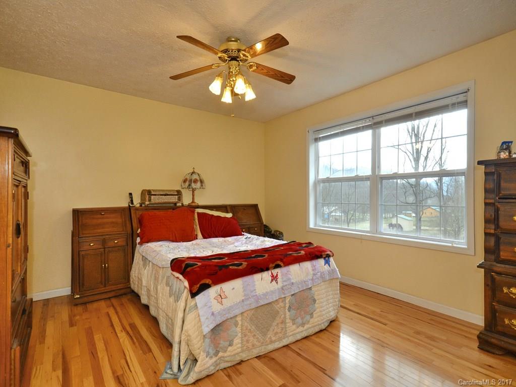 1010 Wesley Creek Road Clyde, NC 28721 - Photo 6 of 12 a bedroom with a bed and a chandelier