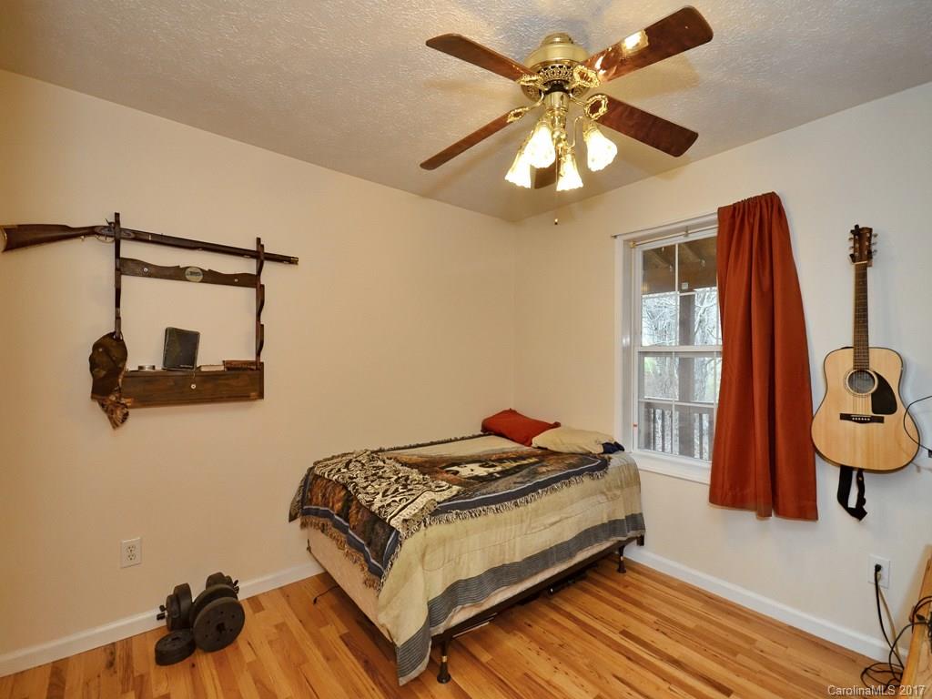 1010 Wesley Creek Road Clyde, NC 28721 - Photo 9 of 12 a bedroom with a bed and a chandelier