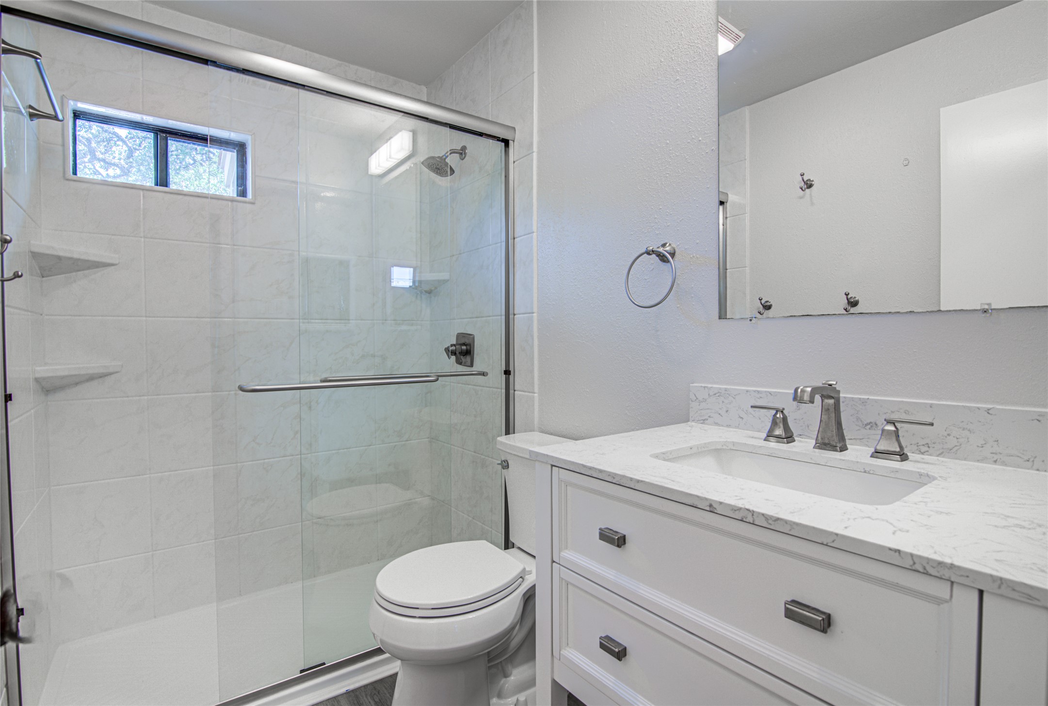 311 West Mary Street Austin, TX 78704 - Photo 18 of 35 A well-lit, contemporary bathroom boasts a vanity with a sleek sink and a glass-enclosed shower.