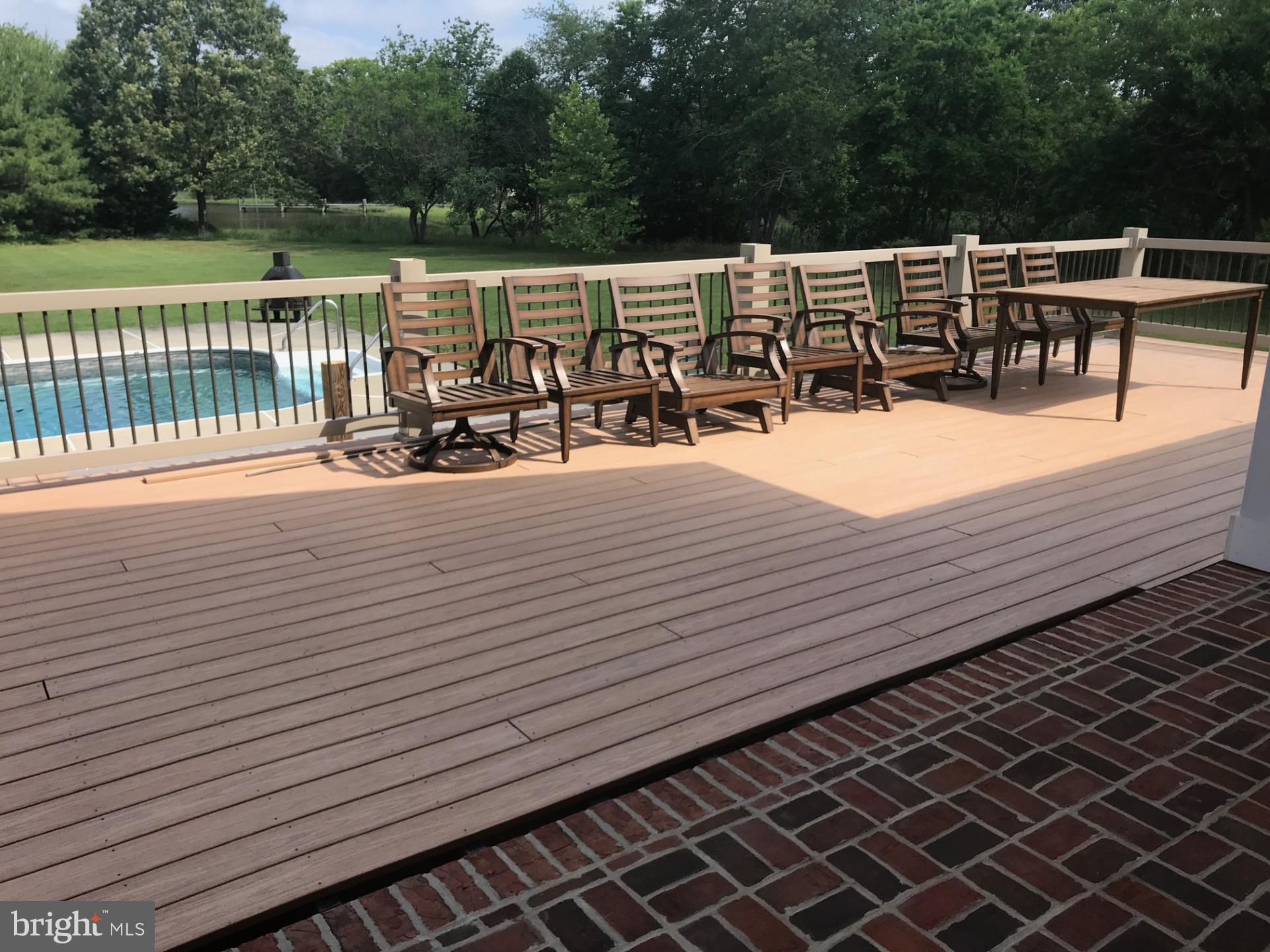 7605 Pendleton Farm Road Easton, MD 21601 - Photo 51 of 62 a view of a roof deck with a dining table and chairs with wooden floor