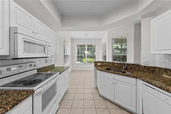a kitchen with granite countertop a sink and a stove