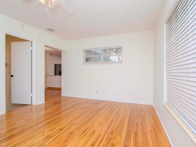 a view of empty room with wooden floor