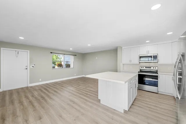 a kitchen with stainless steel appliances a refrigerator stove microwave and cabinets