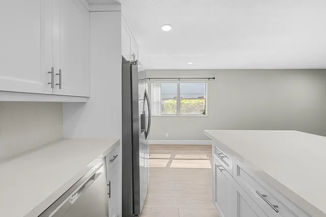 a white toilet sitting next to a white sink and vanity