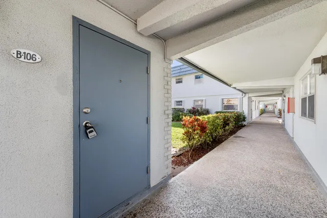 a living room with furniture white walls and kitchen view