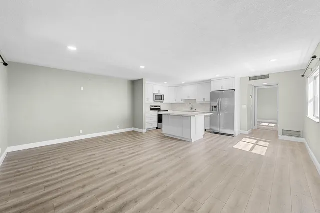 a view of kitchen with wooden floor and electronic appliances