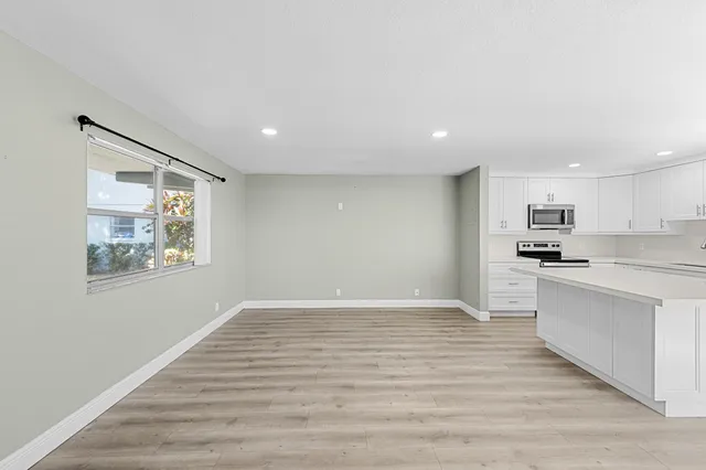 a view of a kitchen with stainless steel appliances a refrigerator sink and stove