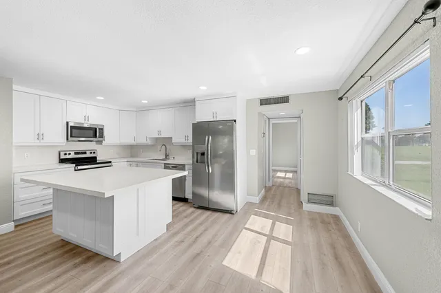 a kitchen with stainless steel appliances a refrigerator sink and stove