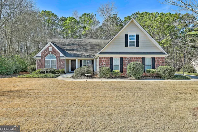 a front view of a house with yard and green space