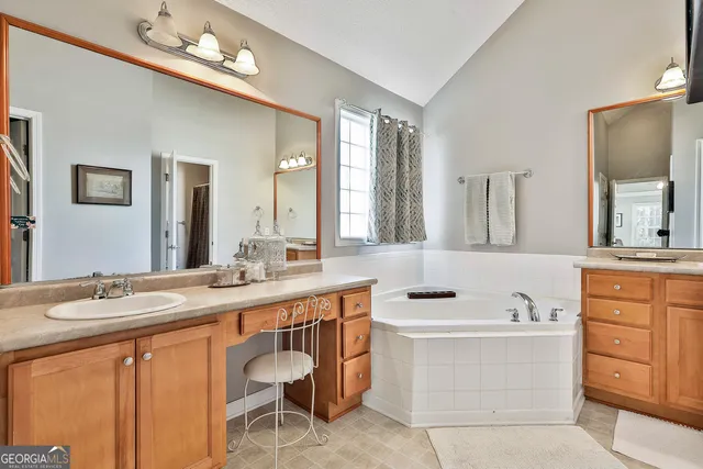 a bathroom with a tub a sink and a mirror
