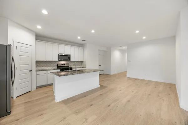 a kitchen with a refrigerator and white cabinets