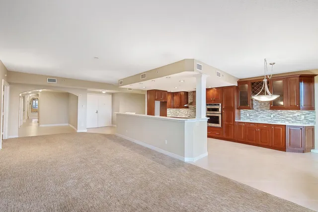 a view of an empty room with kitchen