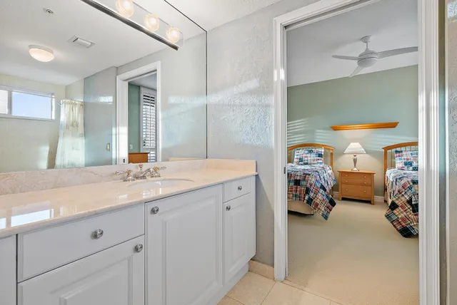 a en suite bathroom with a double vanity sink and a mirror