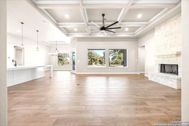 a large white kitchen with a large kitchen island white cabinetry and wooden floor