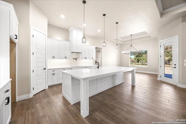 a large white kitchen with a large window