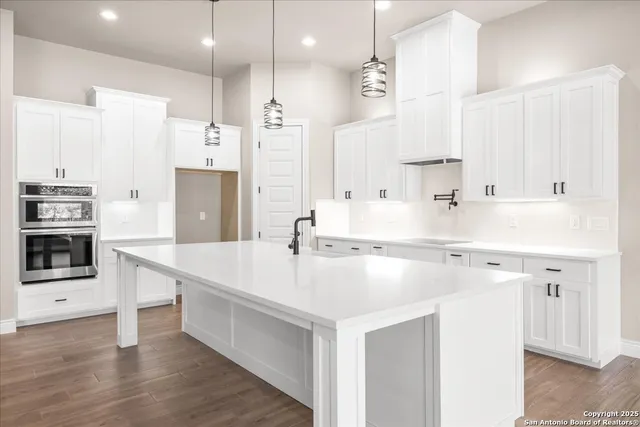 a view of a kitchen with white cabinets