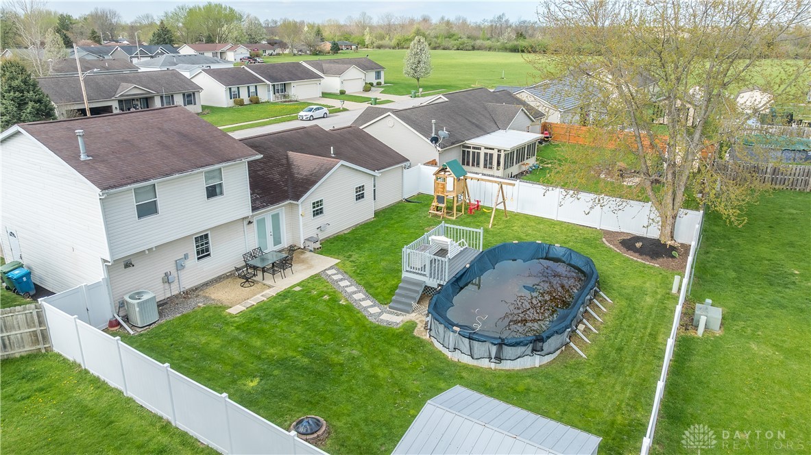 1442 Langdon Road Sidney, OH 45365 - Photo 34 of 34 This spacious yard features an above-ground pool, a patio, and a playset.