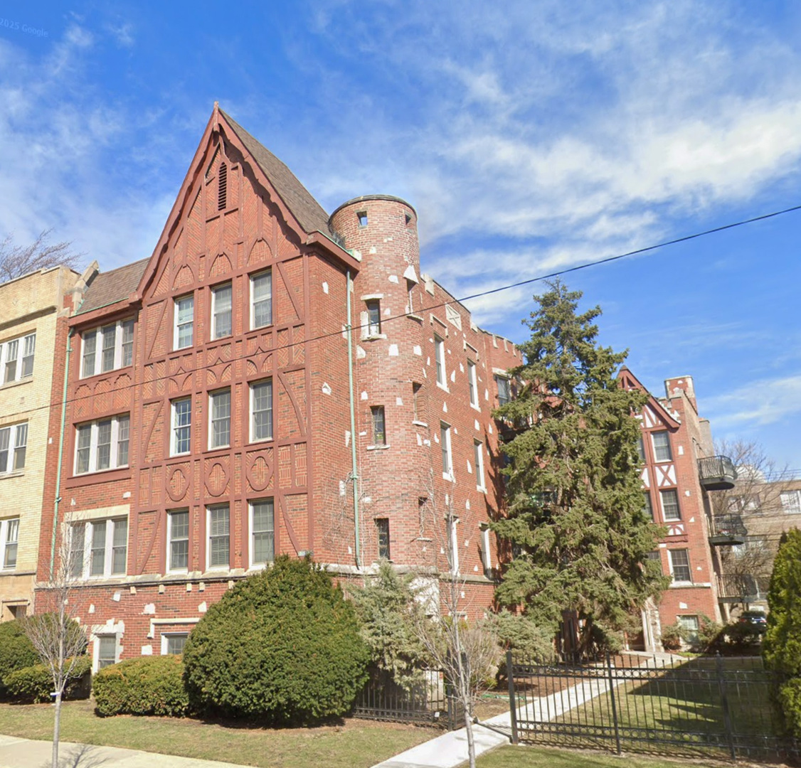 a view of a brick building next to a yard