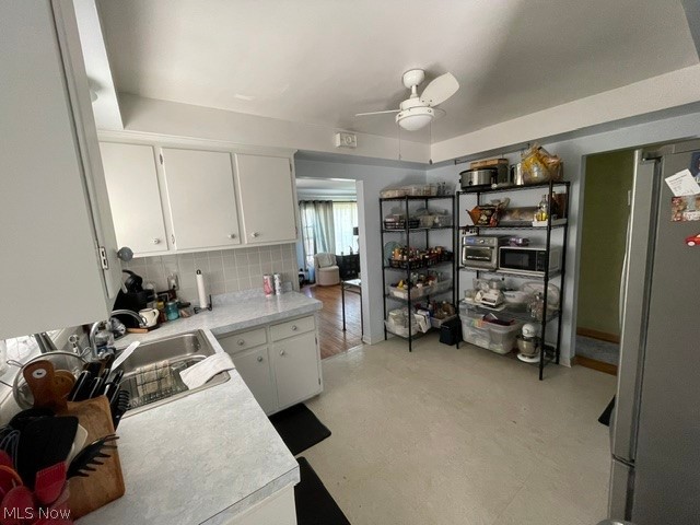 28634 Forest Road Willowick, OH 44095 - Photo 14 of 39 Kitchen featuring white cabinetry, a stainless steel sink, light-toned countertops, and a ceiling fan