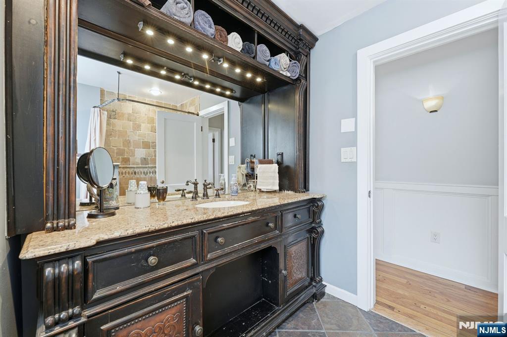 207 Elm Avenue Hackensack, NJ 07601 - Photo 11 of 38 a spacious bathroom with a granite countertop sink a mirror and a