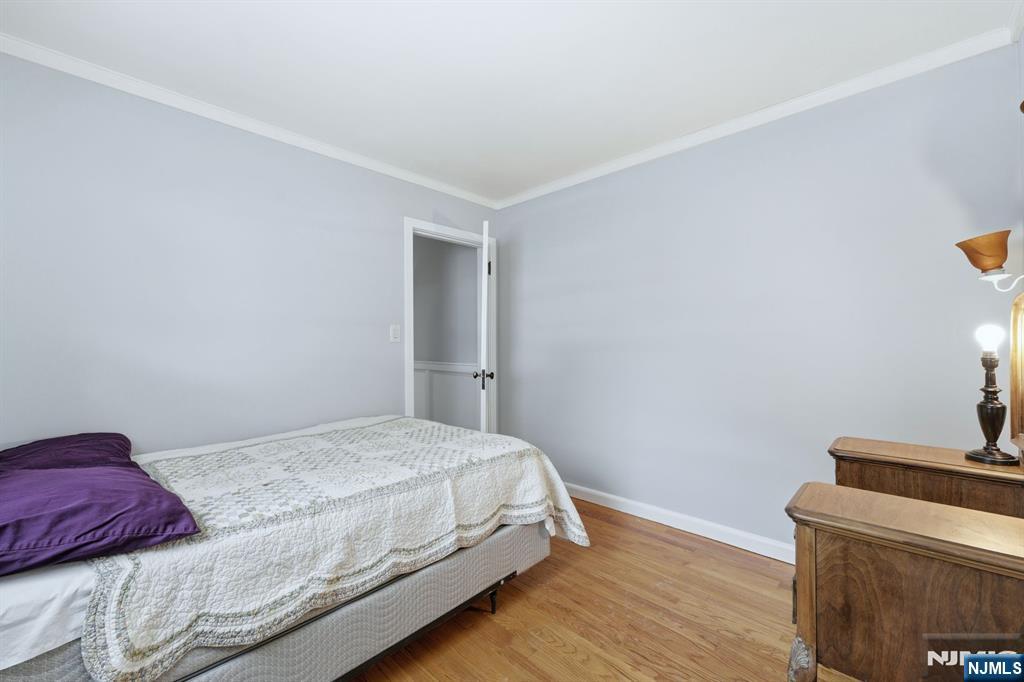 207 Elm Avenue Hackensack, NJ 07601 - Photo 14 of 38 a bedroom with a bed and a lamp with wooden floor