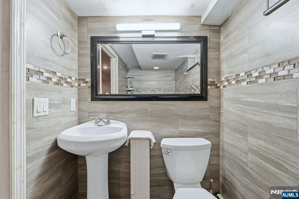 207 Elm Avenue Hackensack, NJ 07601 - Photo 27 of 38 a bathroom with a toilet sink and mirror