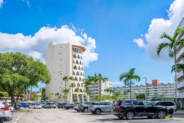 a view of a building and car parked on the side of road
