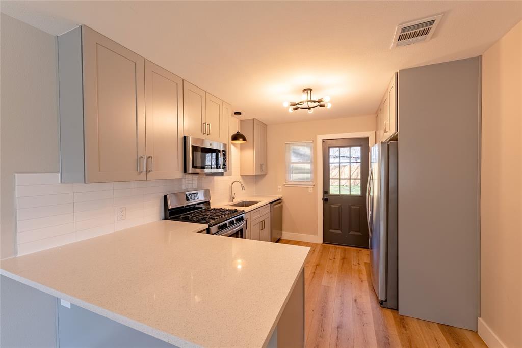 4306 Shallowbrook Trail Austin, TX 78744 - Photo 5 of 16 a room with a bed and a chandelier
