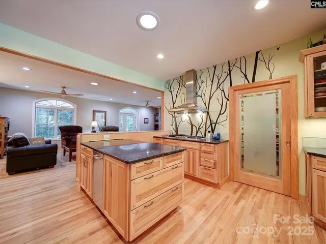 a kitchen with stainless steel appliances granite countertop a stove and a wooden floors