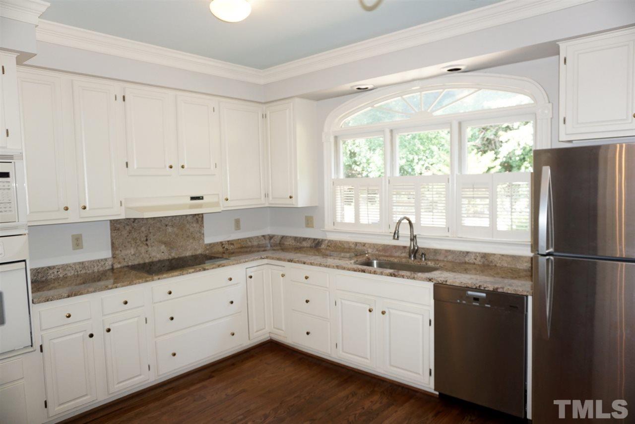 3330 Ridgecrest Court Raleigh, NC 27607 - Photo 5 of 25 a kitchen with granite countertop white cabinets white appliances a sink and a window