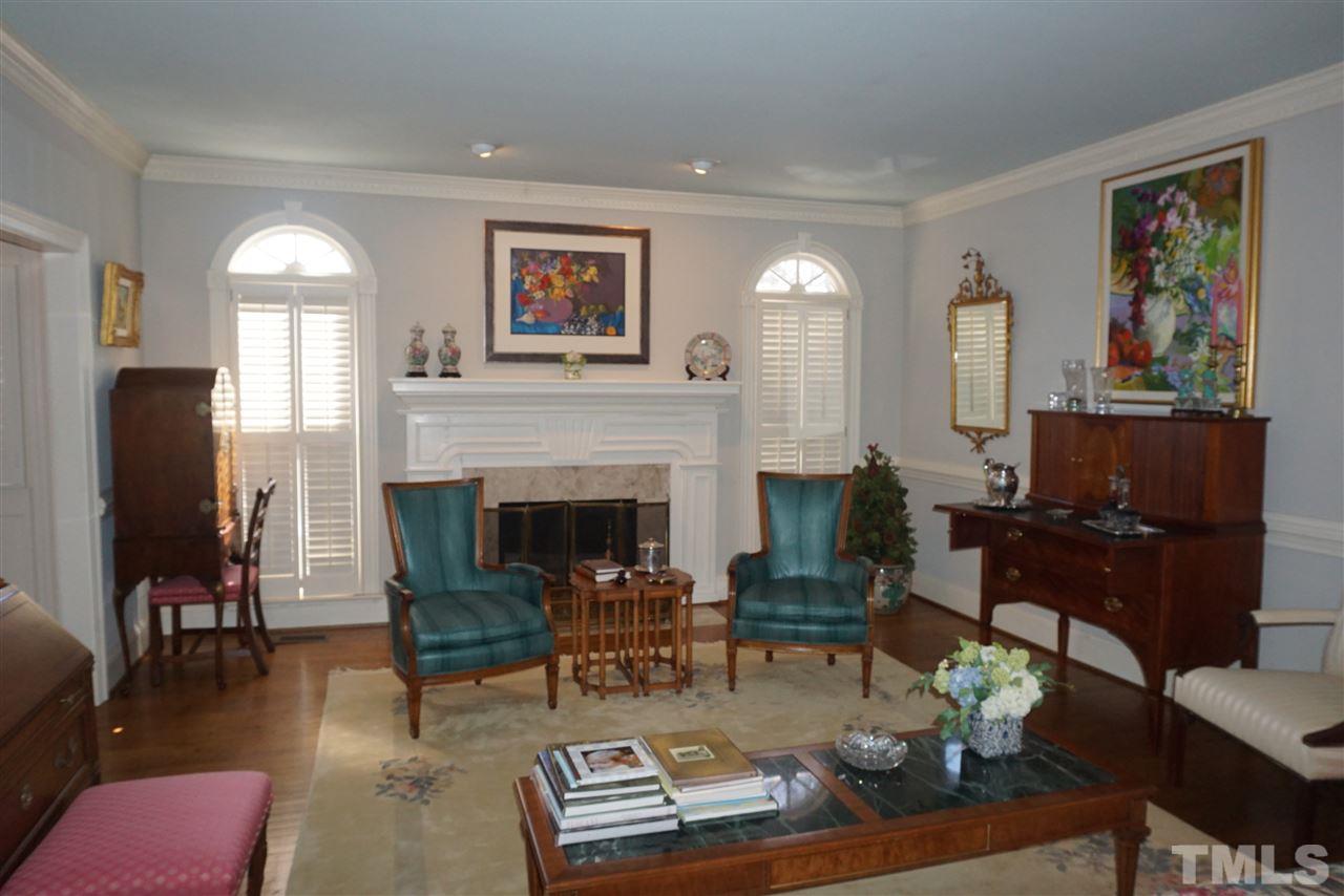3330 Ridgecrest Court Raleigh, NC 27607 - Photo 8 of 25 a living room with furniture a fireplace and a large mirror with wooden floor
