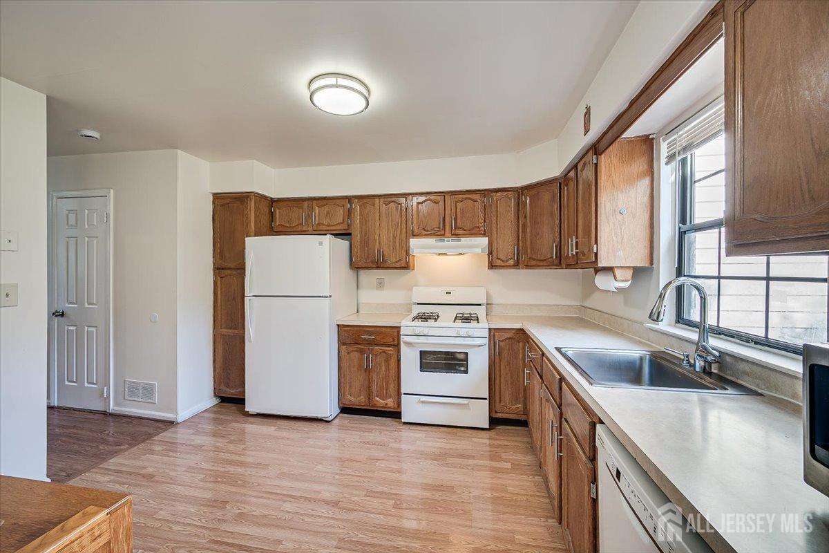602 Maplecrest Road Edison, NJ 08820 - Photo 17 of 42 a kitchen with a sink a stove a refrigerator cabinets and a window