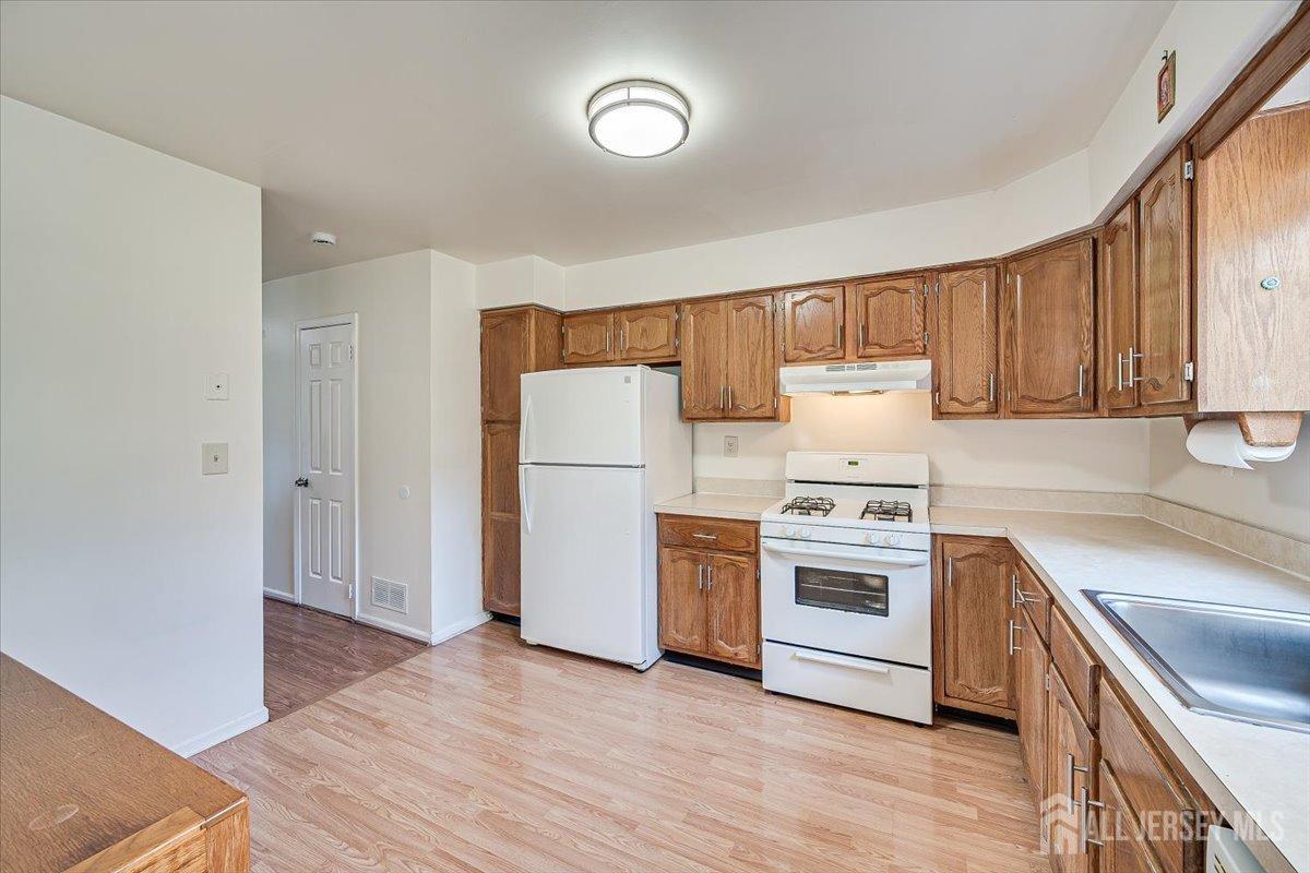 602 Maplecrest Road Edison, NJ 08820 - Photo 18 of 42 a kitchen with a white cabinets and wooden floor