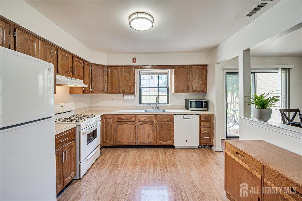 602 Maplecrest Road Edison, NJ 08820 - Photo 21 of 42 a kitchen with granite countertop a stove top oven a sink dishwasher and a refrigerator with wooden floor