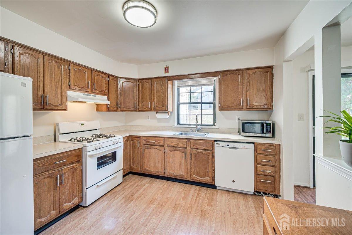 602 Maplecrest Road Edison, NJ 08820 - Photo 22 of 42 a kitchen with granite countertop appliances cabinets wooden floor and a window