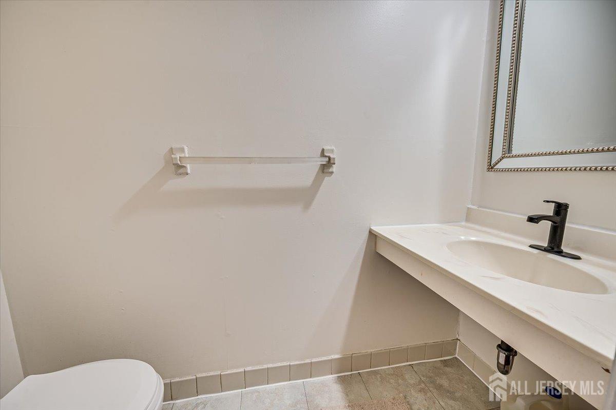 602 Maplecrest Road Edison, NJ 08820 - Photo 23 of 42 a bathroom with a sink a toilet and a mirror
