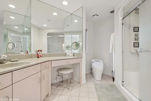 a spacious bathroom with a granite countertop sink a toilet and a shower