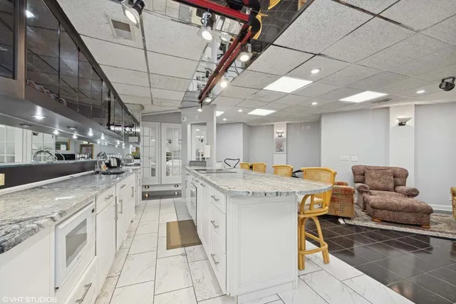 a view of a kitchen and kitchen with stainless steel appliances granite countertop lots of counter top space