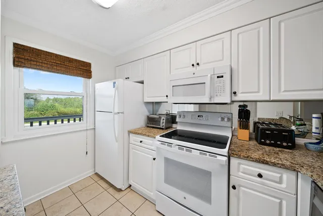a kitchen with white cabinets and white appliances