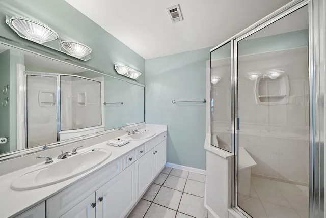 a bathroom with a double vanity sink mirror and shower