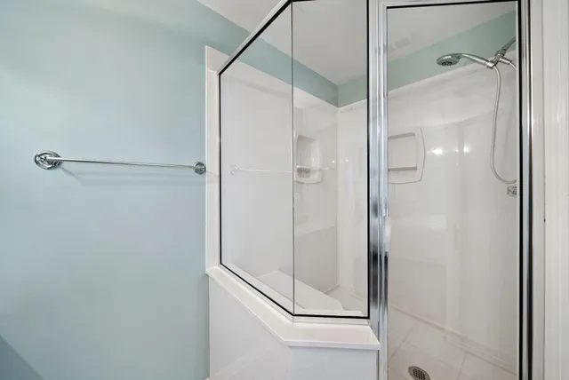 a bathroom with a glass shower door and a glass door