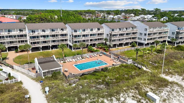 an aerial view of residential houses with outdoor space and ocean view