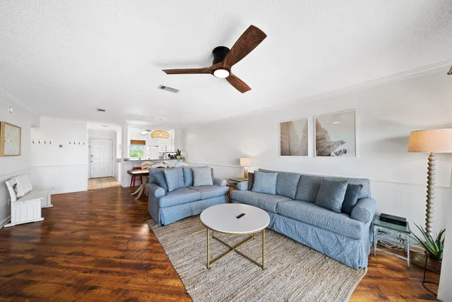 a living room with furniture and a wooden floor