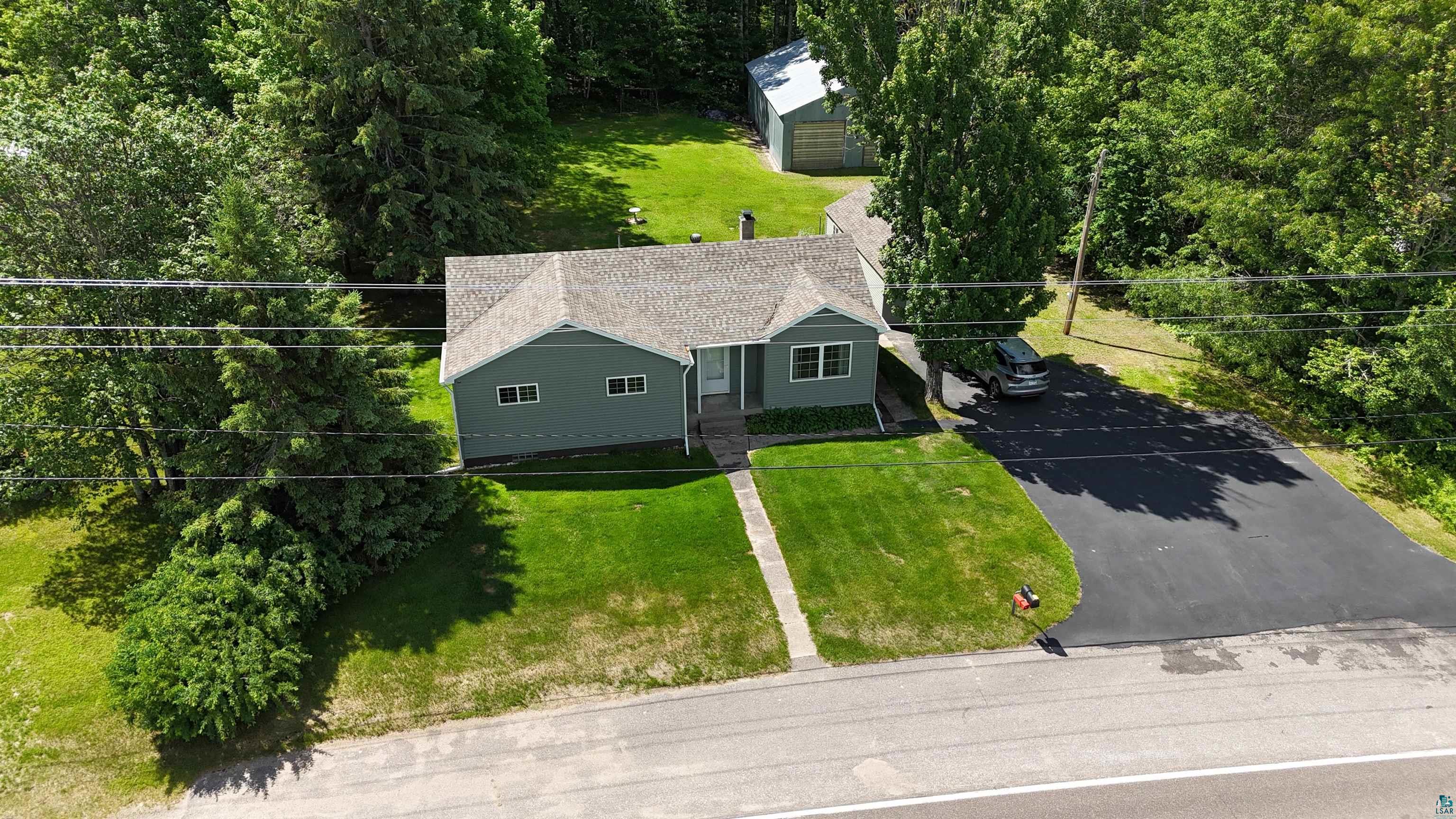 10614 Moose Lake Road Orr, MN 55771 - Photo 7 of 44 Ranch-style residence featuring light green siding, a gray shingle roof, and white-trimmed windows