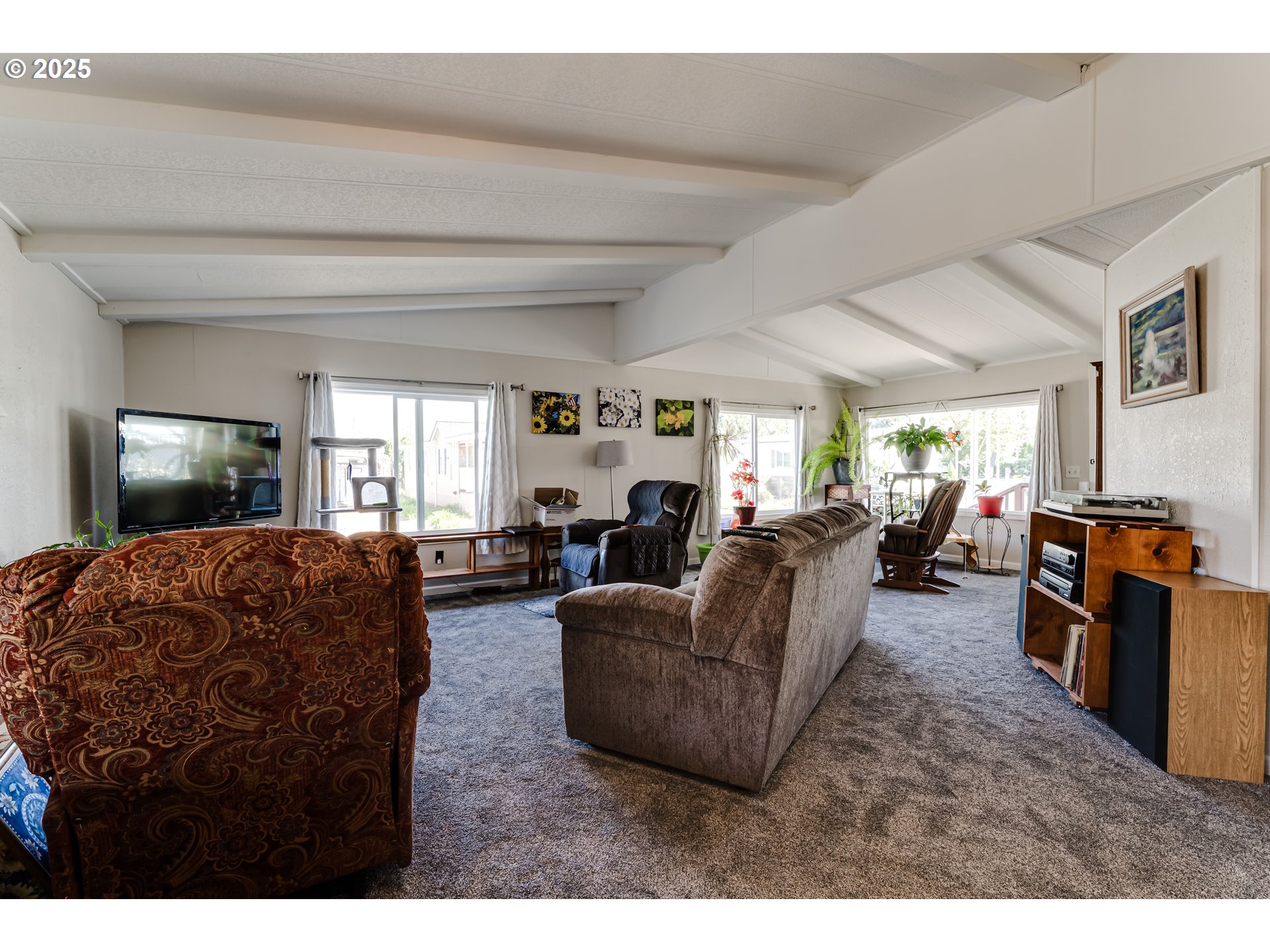 1400 Candlelight Drive, Unit 177 Eugene, OR 97402 - Photo 5 of 32 a living room with furniture and a flat screen tv