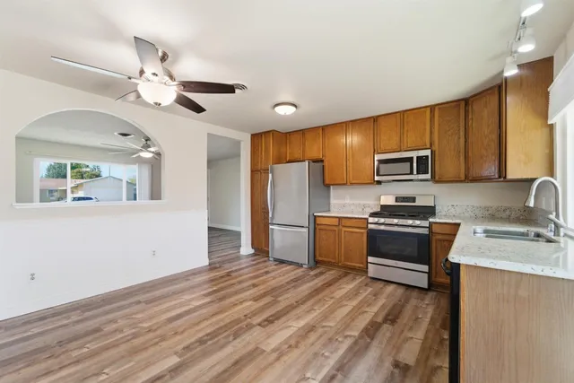 a kitchen with stainless steel appliances a refrigerator sink microwave and cabinets